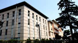 Edificio del Valparma Hospital visto dall'esterno, con alberi e siepi in primo piano