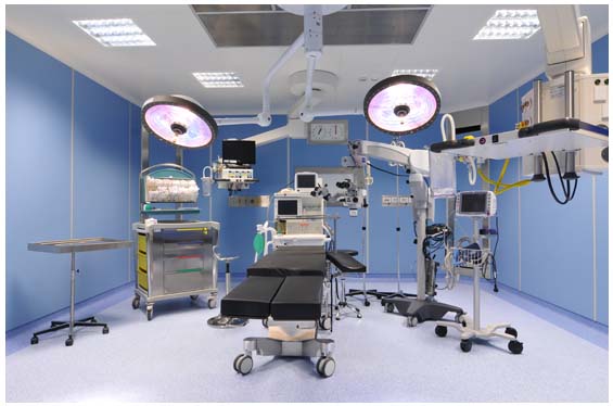 Sala operatoria con tavolo chirurgico, lampade scialitiche, microscopio e monitor