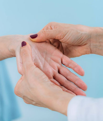 Mani di una specialista che esaminano il palmo della mano di una paziente